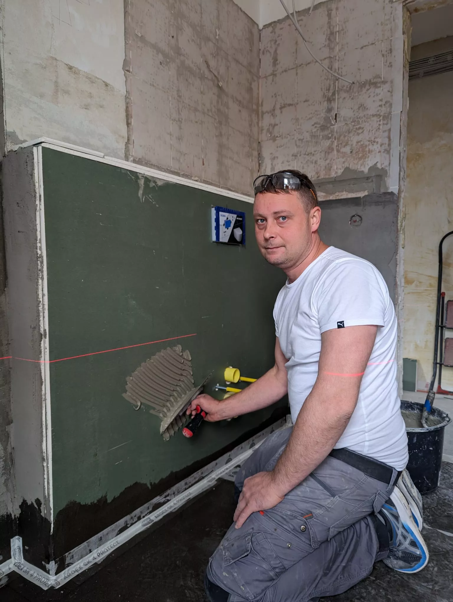Fliesenleger bei der Verlegung von Wandfliesen