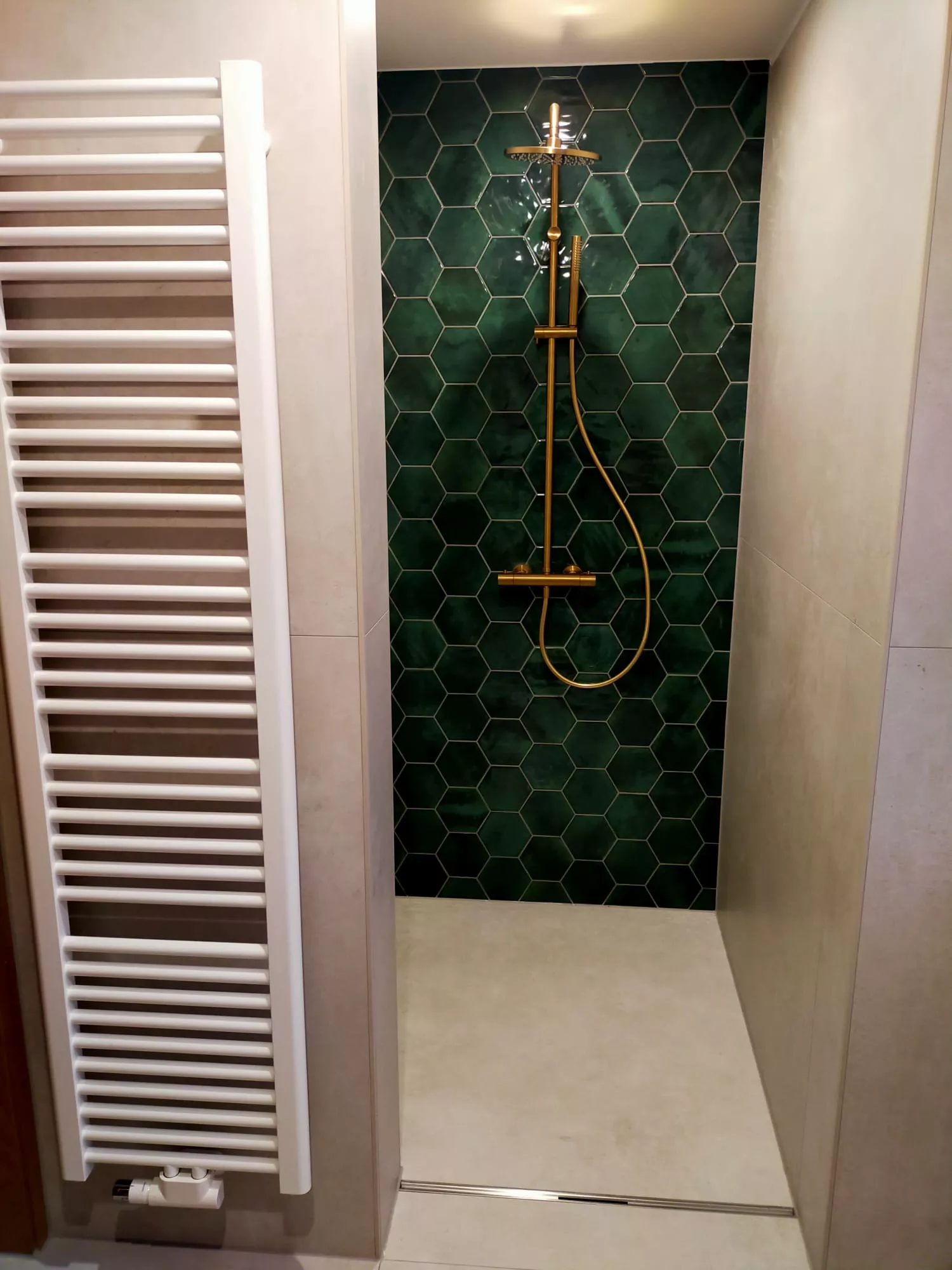 Bodengleiche Dusche mit grünen Hexagon-Fliesen und goldener Regendusche